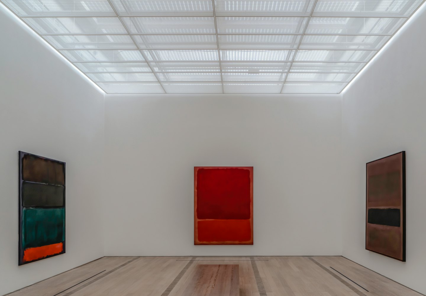 Drei abstrakte Gemälde, die an weißen Galerie-Wänden hängen.