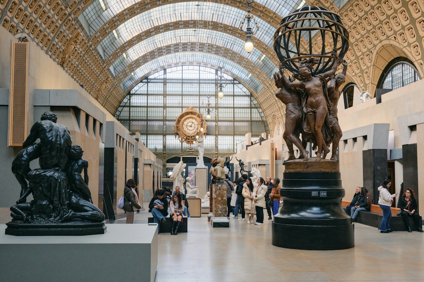 Besucher bestaunen Skulpturen in einer großen Museumshalle.